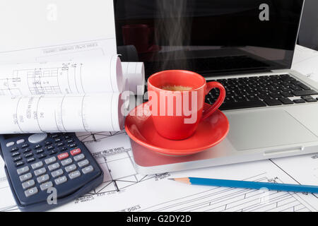 Architekten zeichnen Baupläne mit einem silbernen Laptop mit roten dampfenden Tasse Kaffee Stockfoto