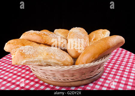 Sesam Brötchen im Korb auf schwarzem Hintergrund Stockfoto