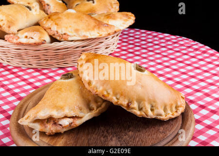 Braun gefüllten Blätterteig mit Pizza Souce auf Runde Holzplatte Stockfoto