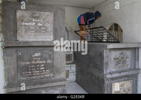 Menschen, die auf Friedhöfen ist nicht ungewöhnlich in der Philippines.Here eine Frau reinigt ein Mausoleum auf dem Carreta Cemetery in Cebu City Stockfoto