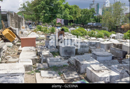 Menschen, die auf Friedhöfen ist nicht ungewöhnlich in der Philippines.Here eine Frau tut hier Wäsche auf Carreta Cemetery in Cebu City Stockfoto