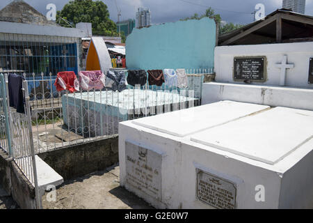 Menschen, die auf Friedhöfen ist nicht ungewöhnlich in der Philippines.Drying waschen hängt zwischen den Gräbern auf dem Carreta Cemetery in Cebu City Stockfoto