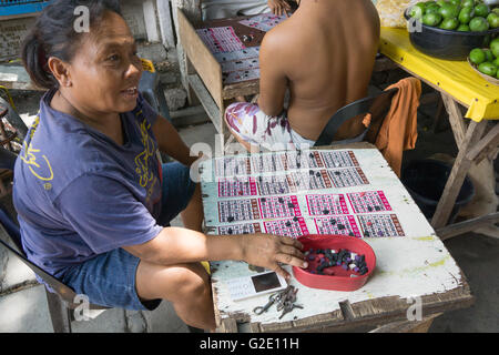 Menschen, die auf Friedhöfen ist nicht ungewöhnlich in der Philippines.Here eine Frau spielt eine Spiel von Bingo. Stockfoto