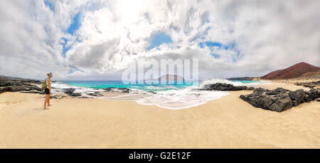 Frau am Sandstrand Playa de Las Conchas mit Vulkan Monte Bermeja, Monta Clara Insel im Hintergrund, La Graciosa Stockfoto