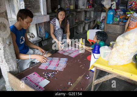 Menschen, die auf Friedhöfen ist nicht ungewöhnlich in den Philippines.Here Leuten innerhalb der Friedhof Gemeinschaft spielen ein Spiel von Bingo Stockfoto