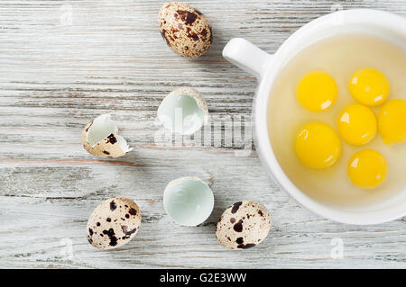 Wachtel Eigelb in einem weißen Teller auf einem hölzernen Hintergrund. Ansicht von oben. Stockfoto