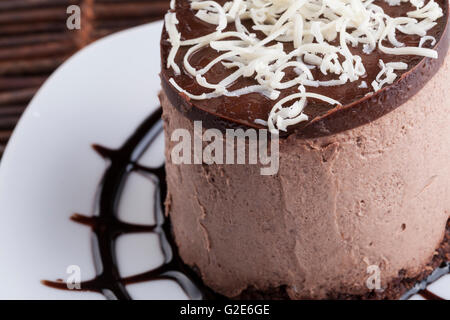 Braune Mousse au Chocolat Torte mit Whie Schokolade obendrauf und Schokolade Liebesherz auf Suggar-Pulver. Stockfoto