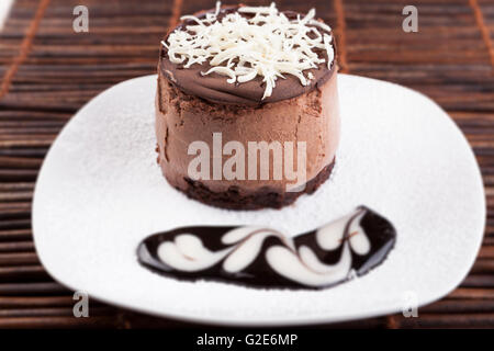 Braune Mousse au Chocolat Torte mit Whie Schokolade obendrauf und Schokolade Liebesherz auf Suggar-Pulver Stockfoto