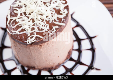 Brown Chocolate Mousse Torte mit Whie Schokolade obendrauf gesetzt auf Schokolade Spider Web Form Stockfoto