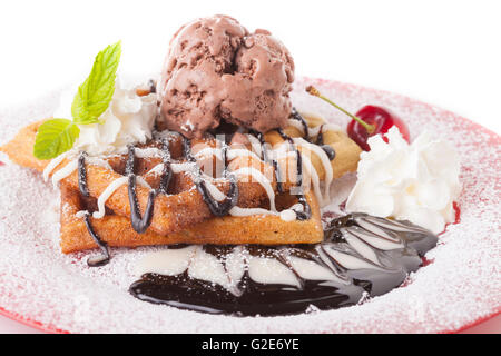 Belgische Waffel mit Schokolade Sirup Schlagsahne und Schokolade-Eis mit roter Kirsche Stockfoto