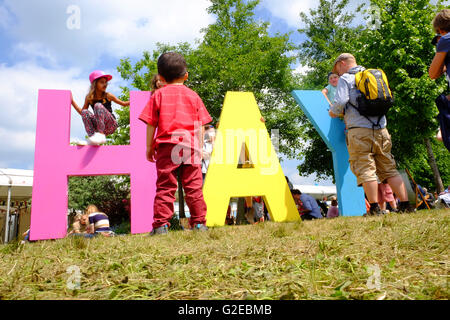 Hay Festival, Wales, Großbritannien - Mai 2016 - Junge Kinder genießen Sie die Gelegenheit, um zu laufen und auf der das Heu Book Festival Rasen in der schönen Wetter spielen. Stockfoto