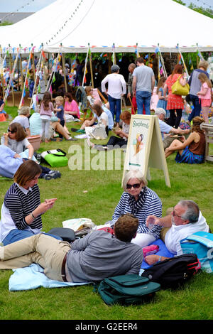 Hay Festival, Wales, UK Mai 2016 - Besucher nutzen die Gelegenheit zum sitzen und entspannen auf dem Festival-Rasen. Stockfoto