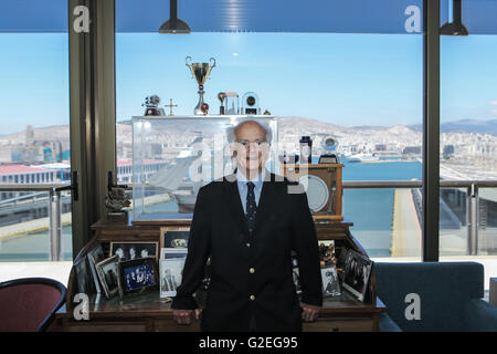 Athen, Griechenland. 16. Mai 2016. Andreas Ilias, Präsident des Vereins Griechenland-China steht neben einem Tisch mit Fotos mit Weltführern und Gedenktafeln in seinem Büro am Hafen von Piräus, Griechenland, am 16. Mai 2016. In der Zielgeraden zum Abschluss des Piraeus Port Authority (PPA) Privatisierung im Juni Andreas Ilias, einer der Protagonisten in der griechischen Versand für Jahrzehnte und Präsident des Vereins Griechenland-China zeigte sich zuversichtlich, dass der Erfolg des Projekts beide Länder profitieren. © Lefteris Partsalis/Xinhua/Alamy Live-Nachrichten Stockfoto