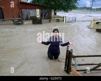 Obernzenn, Deutschland. 29. Mai 2016. Eine Frau steht bis zu den Hüften im Wasser auf einem Reiterhof nach Unwetter in Obernzenn, Deutschland, 29. Mai 2016. Unwetter hat mehrere Orte in Bayern verwüstet. Laut der Polizei und Feuerwehr haben die Stadtteile Flachslanden und Obernzenn den größten Schaden gesehen. Foto: VERA GROESCHL/Dpa/Alamy Live News Stockfoto