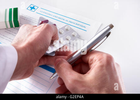 Arzt eine ärztliche Verschreibung mit Dokumente und Medikamente auf einem weißen Glastisch aufschreiben. Horizontale Komposition. Erhöhte Stockfoto