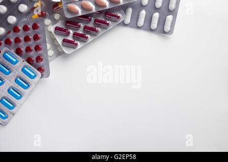 Haufen von Tabletten in Blister-Packungen auf einem weißen Tisch-Hintergrund. Horizontale Komposition. Ansicht von oben Stockfoto