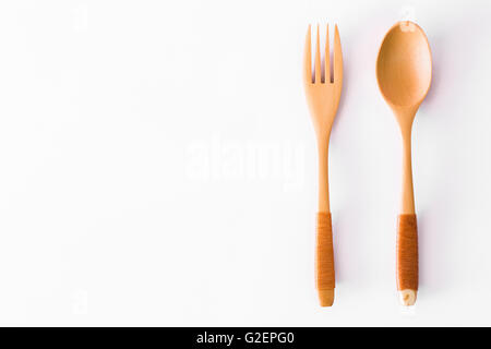 Löffel und Gabel aus Holz gebaut, mit einem weißen Hintergrund aufgeteilt. Stockfoto