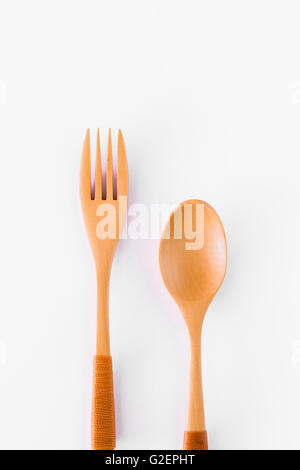 Löffel und Gabel aus Holz gebaut, mit einem weißen Hintergrund aufgeteilt. Stockfoto