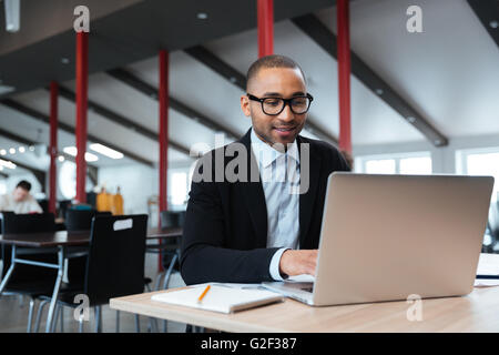 Gut aussehend Geschäftsmann arbeiten und mit Laptop im Büro Stockfoto
