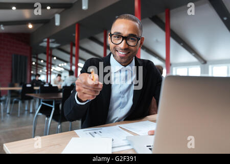Geschäftsmann, Lächeln und zeigen mit Pncil am Arbeitsplatz Stockfoto