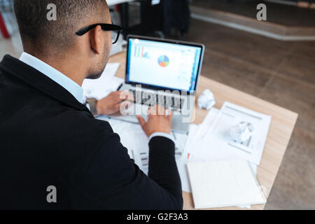 Rückansicht des Kaufmanns Tippen auf Laptop im Büro Stockfoto