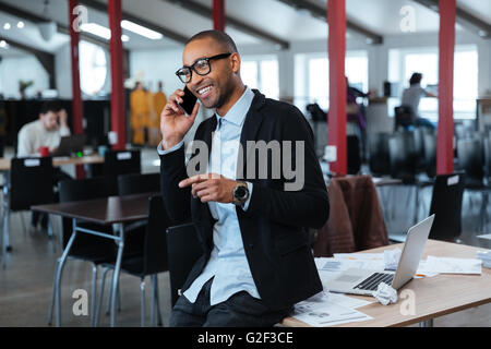 Glücklich Kaufmann auf dem Smartphone im Büro sprechen Stockfoto