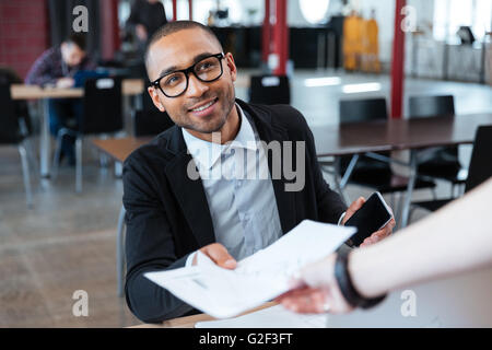 Junge Unternehmer geben jemand im Büro Papiere Stockfoto