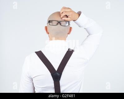 Rückseite ein glatzköpfiger Mann in einem weißen Hemd mit Brille auf Nacken. kratzt sich am Kopf Stockfoto