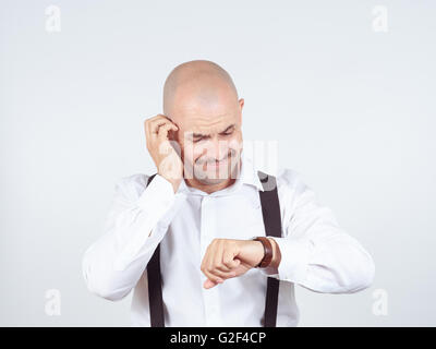 Glatzköpfiger Geschäftsmann sieht auf seine Uhr und spät. Stockfoto