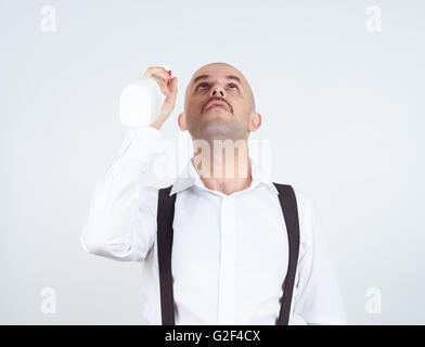 Glatze männliche Reinigung Arbeiter sprühen flüssiges Waschmittel vor ihm, Stockfoto