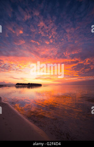 Erstaunlichen abstrakten Hintergrund. Schönen Sonnenuntergang Farben auf den Malediven. Lange Steg und Overwater-Luxusvillen Stockfoto