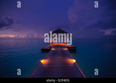 Erstaunlichen abstrakten Hintergrund. Schönen Sonnenuntergang Farben auf den Malediven. Lange Steg und Overwater-Luxusvillen Stockfoto