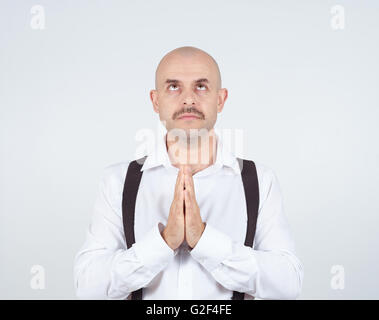 Glatze Mann, der betet, Hände flehte, gefalteten Hoffnung des Wunders auf Hintergrund isoliert. Stockfoto