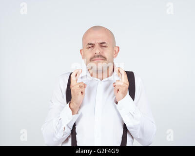 Für besondere Moment wartet. Glatzkopf in Hemd Daumen gekreuzt. Auf Hintergrund isoliert Stockfoto