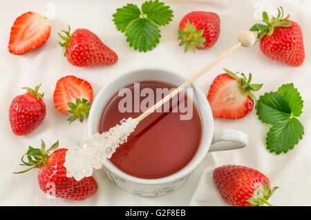 Frische Erdbeeren mit Erdbeersaft auf weißer Seide Stoff Stockfoto