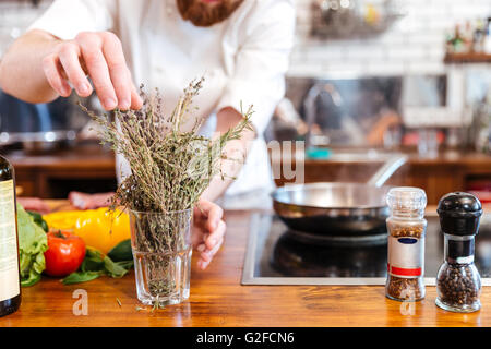 Abgeschnitten Bild ein Chef Koch bereitet Lebensmittel in der Küche Stockfoto