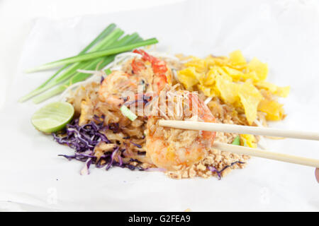 Gebratene Nudeln Thai-Stil mit Garnelen. Unter Rühren braten Nudeln mit Garnelen in (Pad Thai) Thai-Küche auf weiße Farbe Wrapper Nahrung. Stockfoto