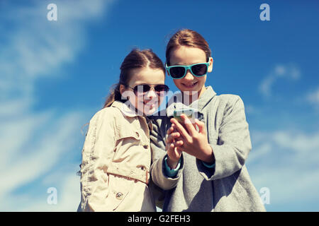 glückliche Mädchen mit Smartphone unter Selfie im freien Stockfoto
