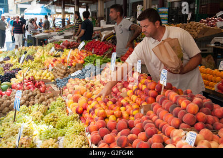 Griechische Männer verkaufen Obst an Fisch und Obst Straßenmarkt in Omonia Monastriki Agora Athens. Stockfoto