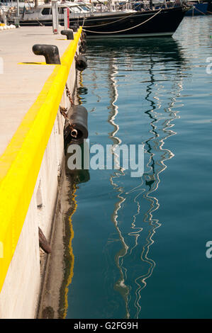 Wasserspiegelungen Jacht Mast Masten vertäut am Zea Marina in der Nähe von Piräus in Athen verankert. Stockfoto