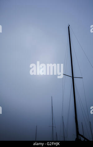 Segelboot Masten gegen nebligen Himmel in der Abenddämmerung Stockfoto