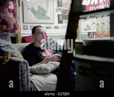 Junger Mann spielen Videospiele im Schlafzimmer Stockfoto