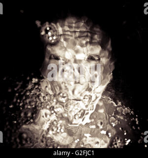 Weibliches Gesicht unter Wasser mit Luftblasen Stockfoto