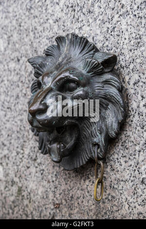 Reich verzierte Löwenkopf aus Messing auf einer Steinmauer Stockfoto