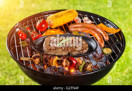 Verschiedene Arten von Fleisch auf Grill serviert mit Rasen auf Hintergrund Stockfoto