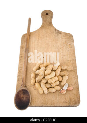 Monkey Nuts aka Erdnüsse in Schalen. Isoliert an Bord mit Löffel. Erzwungene Perspektive-Effekt. Stockfoto