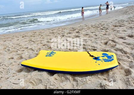 Eine gelbe Boogie Board Verlegung in den Sand am Strand Stockfoto