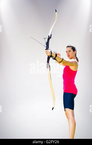 Das zusammengesetzte Bild der Sportlerin üben Bogenschießen auf weißem Hintergrund Stockfoto