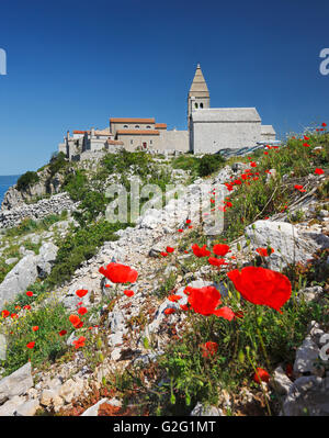 Die hügelige Lubenice-Stadt auf der Insel Cres mit Mohn Blumen in der front Stockfoto