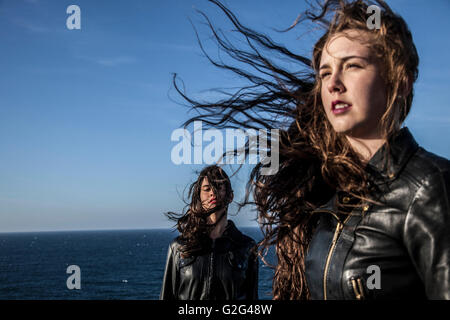 Zwei junge Frauen mit Haar im Wind vom Meer Stockfoto